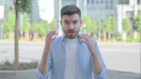 Outdoor Portrait of Young Man Reacting to Loss