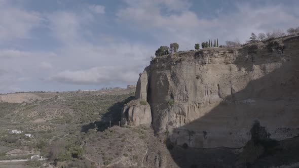 Aerial flight to massive stone pillar, vertical cliffs in Ronda, Spain