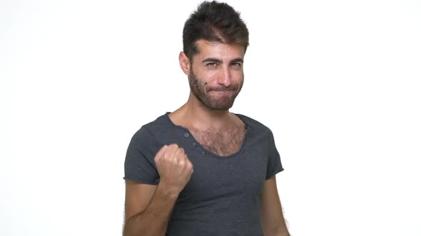 Picture of Hispanic Young Man Wearing Grey Tshirt Looking at Camera Enjoying Success with Clenched