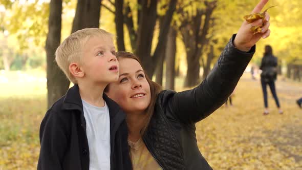 Beautiful Mother Walk in the Autumn Park with Two Sons.