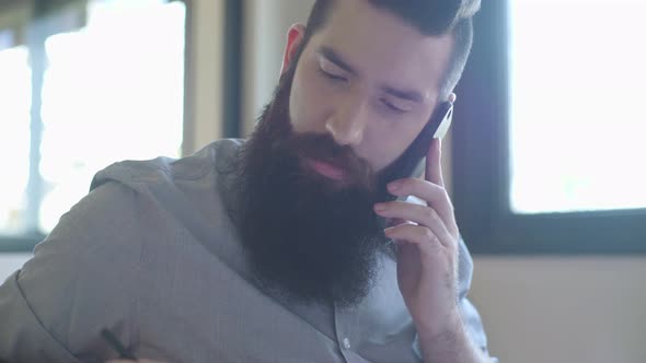 Bearded man talking on cell phone