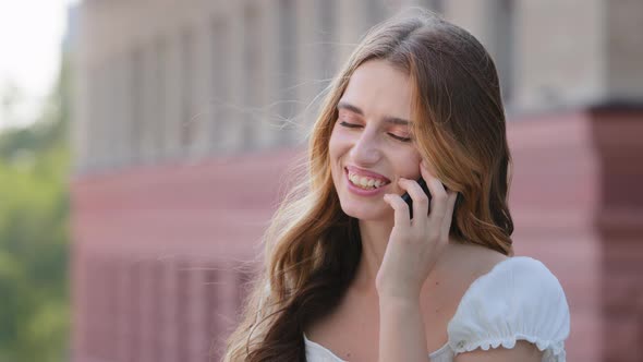 Smiling Millennial Woman Enjoying Talking on Phone Outdoors Happy Young Girl Holds Cellphone Making