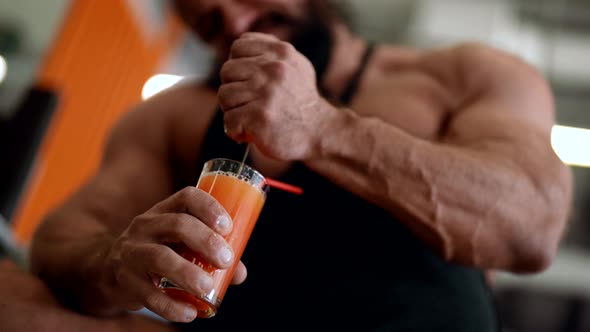 Powerlifter is Squeezing Fresh Grapefruit Juice in Glass in Gym and Drinking Muscular Hands