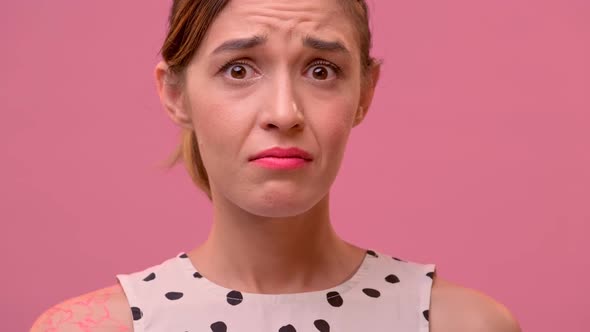 Close Up Portrait of a Confused Young Female on a Pink Background.