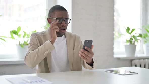 Upset African Man Reacting to Loss on Smartphone