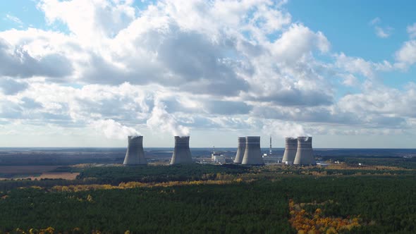 Nuclear Power Station with Steaming Cooling Towers Near the Forest Aerial View