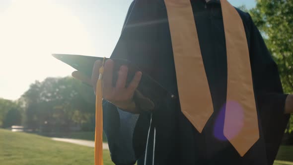 Rewarding Graduate Student Holding a Hat in His Hand