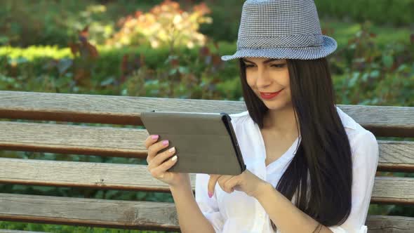 Girl Uses Tablet on the Bench