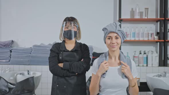 Portrait of Asian female stylist  wearing mask stand with young customer in beauty salon shop.