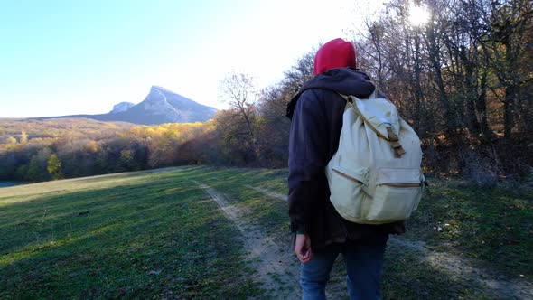 Man is Enjoying Nature Walking Alone in Sunny Forest at Autumn Day