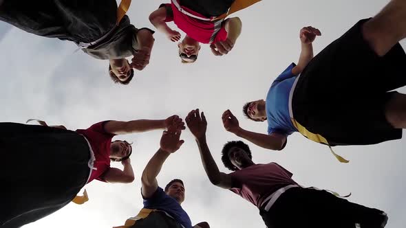 A group of young men playing flag football on the beach.