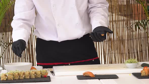 Male Chef in Uniform Cutting Fresh Salmon for Sashimi