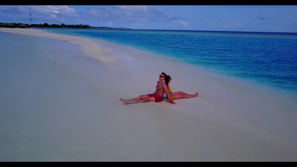 Romantic couple in love on paradise resort beach break by blue green water with white sandy backgrou