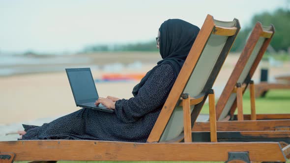 good looking Muslim women sitting outside working according to the slogan work form home