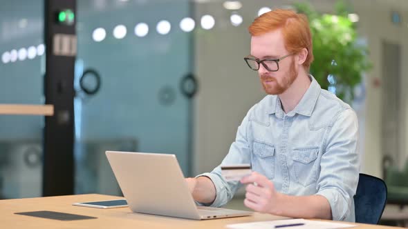 Online Payment Failure on Laptop for Redhead Man in Office 