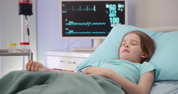 Sick Little Girl Sleeping in Bed Having Blood Transfusion in Hospital