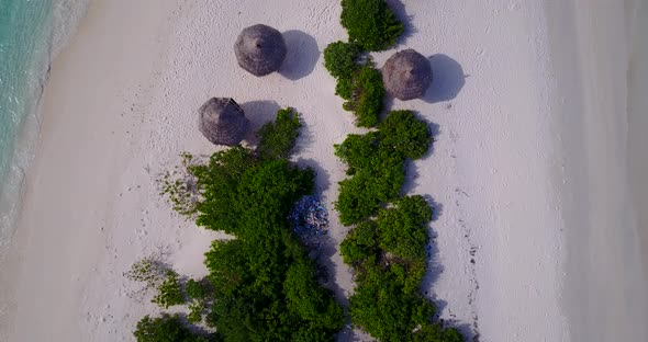 Wide angle drone tourism shot of a white paradise beach and aqua blue water background in vibrant 4K