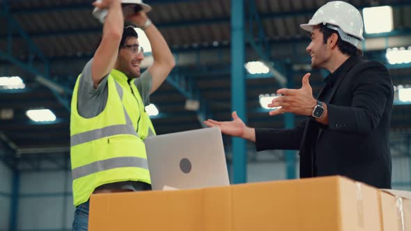 Two Factory Worker Celebrate Success Together in the Factory