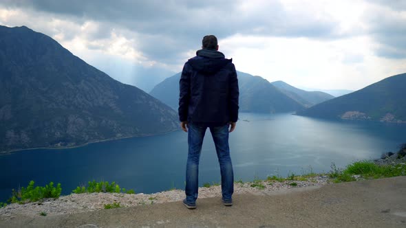 Man Standing on Mountain Peak Enjoys Mindblowing Landscape