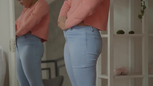 Weight Gain Woman Buttoning Pants with Difficulties