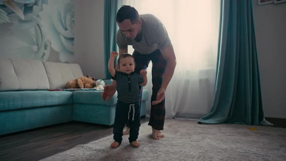 Baby Taking First Steps with Father's Help at Home