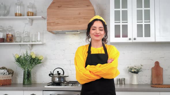 Portrait Smiling Woman Housewife Turns Head and Crossing Hands in Home Kitchen