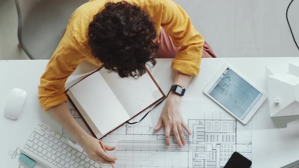 Top Down of Female Architect Drawing Construction Plan