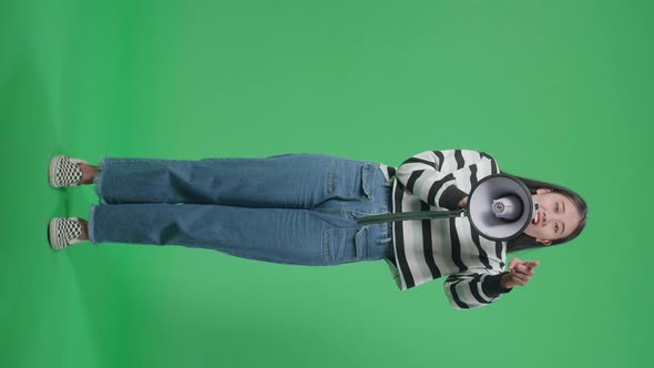 Full Body Of An Asian Woman Speaking On Megaphone In The Green Screen Studio