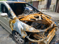 Closeup of burnt rusted car left on the city street destroyed by fire - PhotoDune Item for Sale