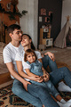 A young married couple with their cute daughter. The family spends time at home - PhotoDune Item for Sale