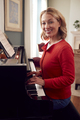 Portrait Of Mature Woman At Home Enjoying Learning To Play Piano - PhotoDune Item for Sale