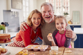Portrait Of Grandparents With Granddaughter Eating Homemade Cupcakes In Kitchen At Home - PhotoDune Item for Sale