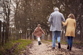 Rear View Of Grandparents With Granddaughter Outside Walking Through Winter Countryside - PhotoDune Item for Sale