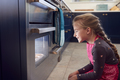 Girl Waiting By Oven In Kitchen At Home For Cakes To Bake - PhotoDune Item for Sale