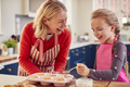 Grandmother With Granddaughter Baking And Decorating Cakes Around Kitchen Counter At Home - PhotoDune Item for Sale
