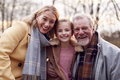 Portrait Of Grandparents With Granddaughter Outside Walking Through Winter Countryside - PhotoDune Item for Sale