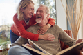 Smiling Senior Couple At Home Enjoying Looking Through Photo Album Together - PhotoDune Item for Sale
