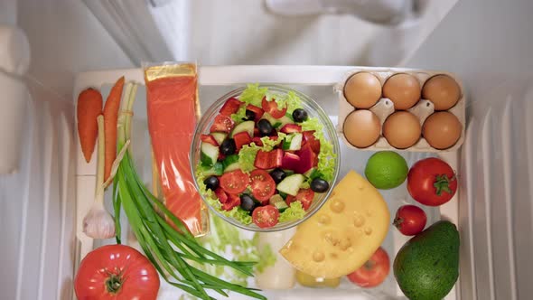 Woman's hands takes healthy green salad.