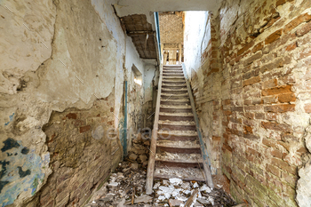 of ancient building or palace with cracked plastered brick walls and narrow steep wooden staircase ladder.