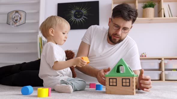 Father and Toddler Son Having Fun at Home Playing with Wooden Toys , Indoor