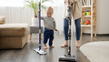 Little baby boy helping his mother doing cleanup at home and vacuming carpet. - PhotoDune Item for Sale