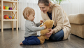 Happy smiling mother teaching her baby son and playing with teddy bear - PhotoDune Item for Sale