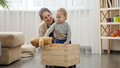 Little baby boy with mother collecting toys in wooden toy box at living room - PhotoDune Item for Sale