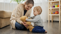 Cute baby boy with mother playing on floor with teddy bear - PhotoDune Item for Sale