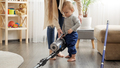 Cute baby boy holding vacuum cleaner and helping his mother doing cleanup - PhotoDune Item for Sale