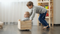 Two brothers playing and riding in wooden toy box. Children playing and having fun at home - PhotoDune Item for Sale