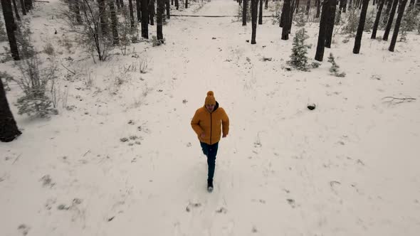 a Man Runs in a Snowcovered Forest Alone Facing the Camera