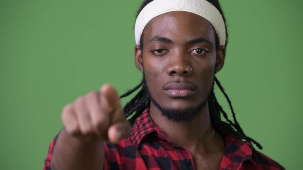 Young Handsome African Man with Dreadlocks Against Green Background