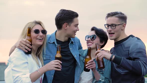 Happy Friends Drinking Beer, Cheering With Bottles And Dancing Outdoors.