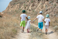 Four children holding hands, siblinlings or friends, on walk in rural area, rear view - PhotoDune Item for Sale